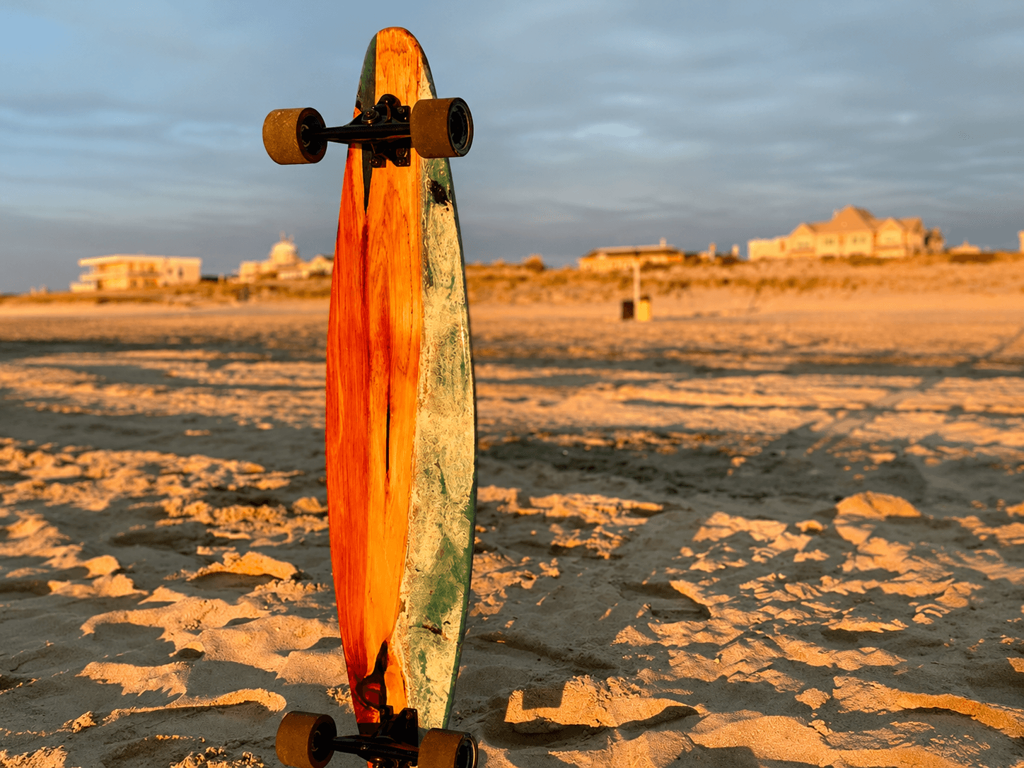 Cedar Ocean longboard standing on beach at golden hour