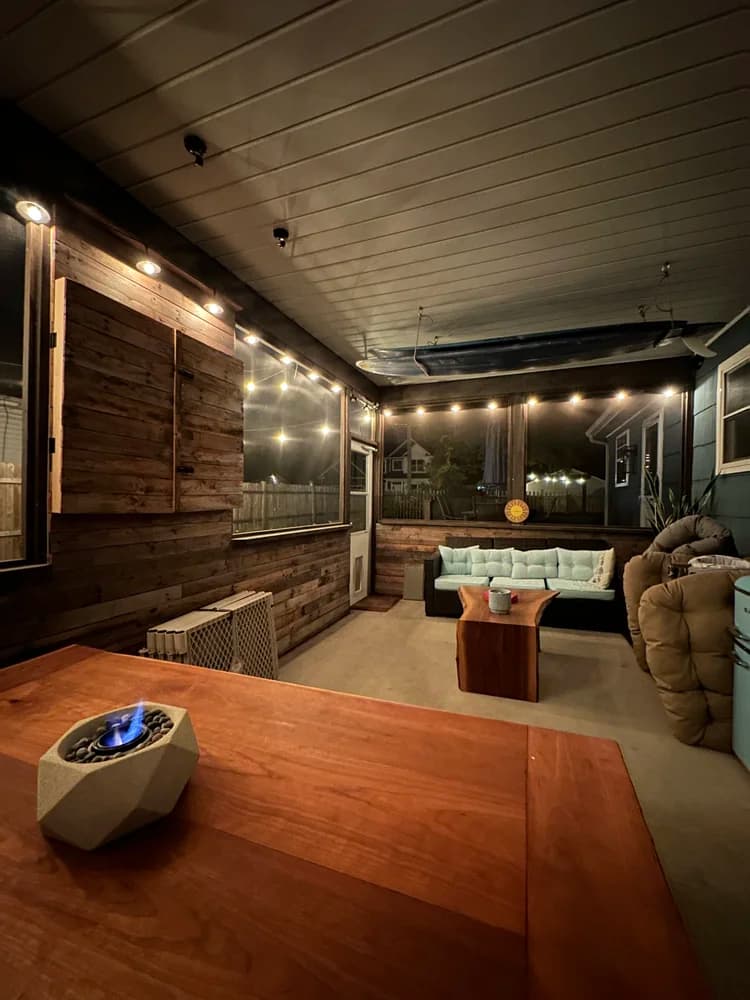 Covered outdoor porch with reclaimed wood walls at night
